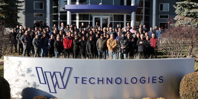 Photo of IW Technologies employees in front of building